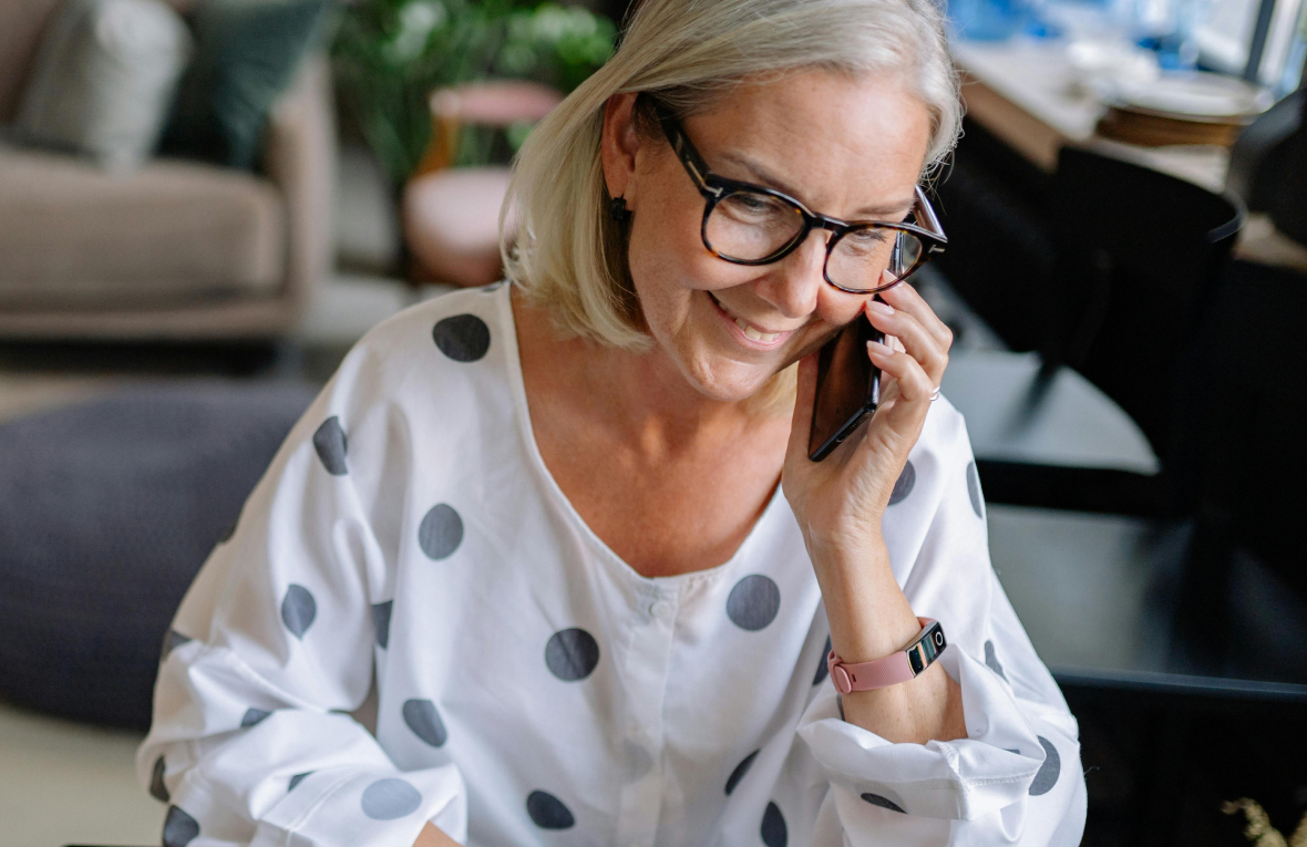 mujer mayor sonrie mientras hace una llamada