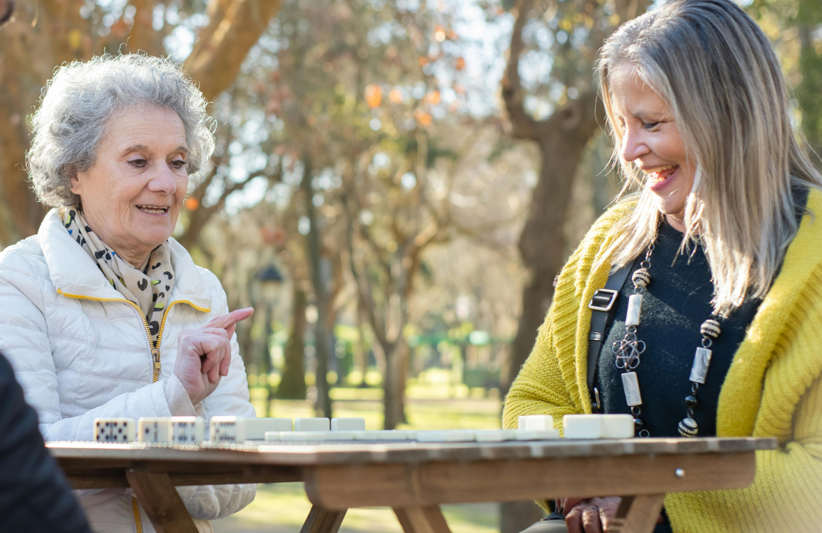 cuidadora juega a dominio con una persona mayor
